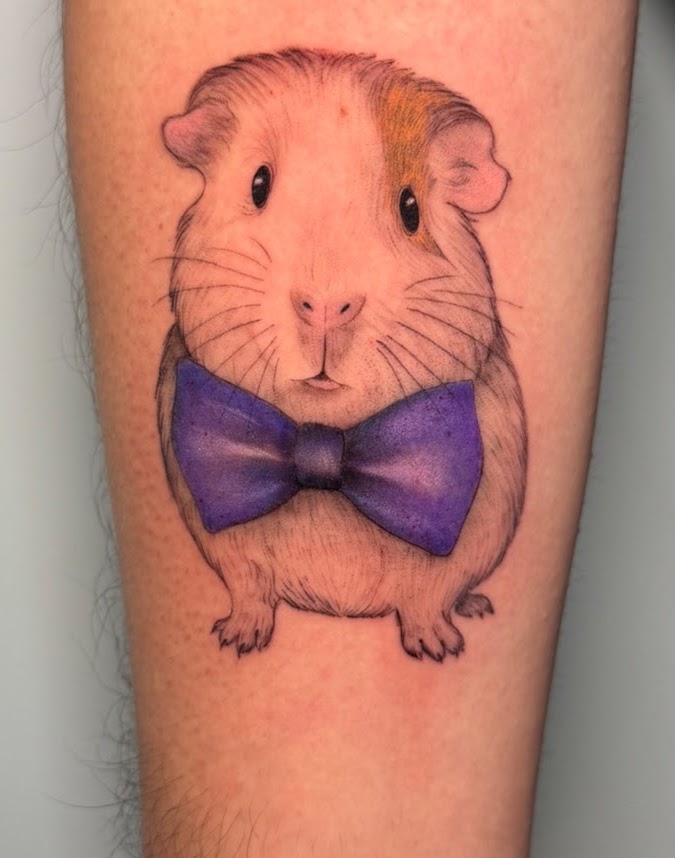 Tatuaje cobayo cuy con moño a color ilustrativo — Krimatt, CAOS Art Tattoo Chile