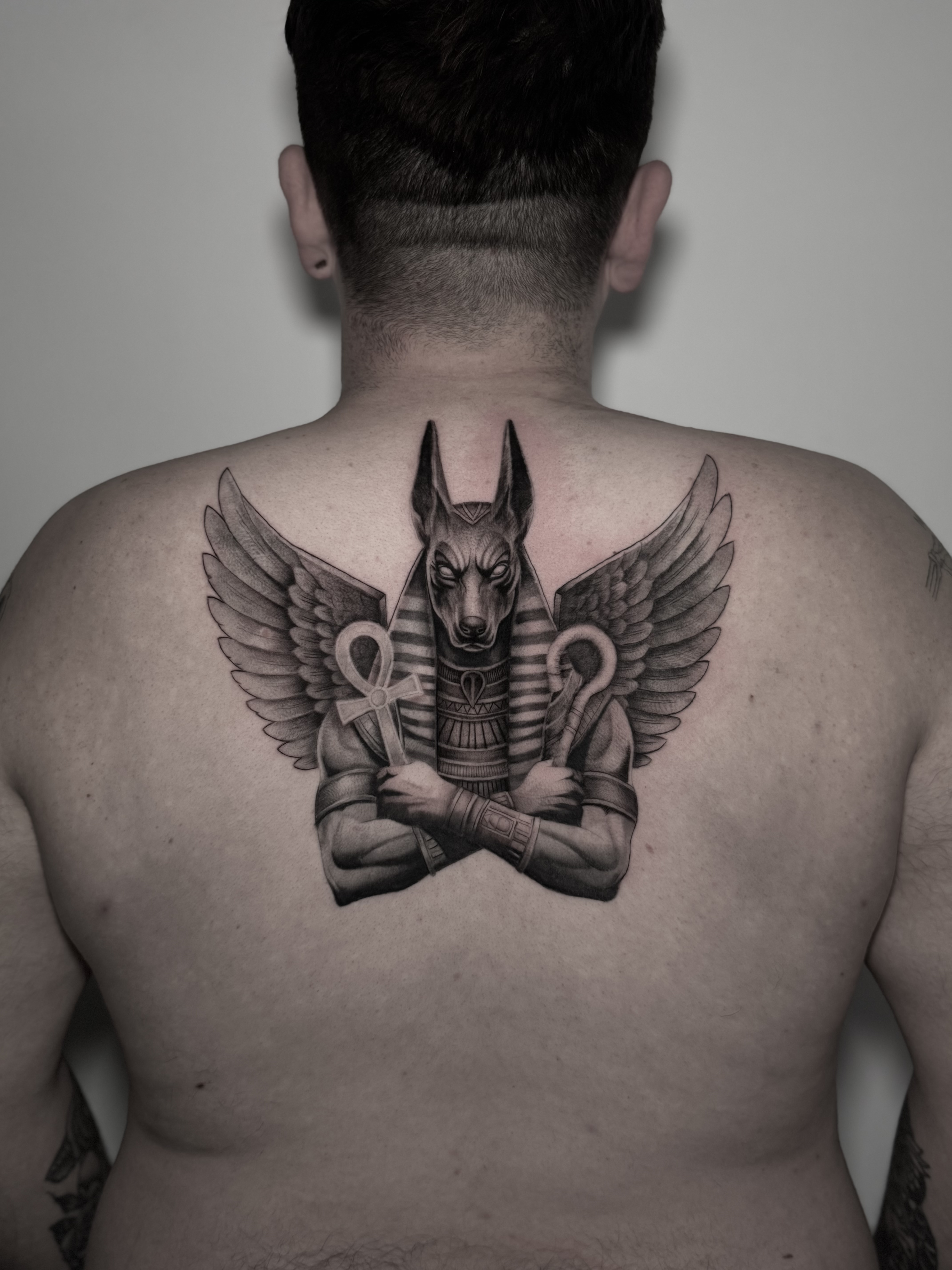 Tatuaje Anubis alado con cetro y ankh en la espalda black grey — Krimatt, CAOS Art Tattoo Chile