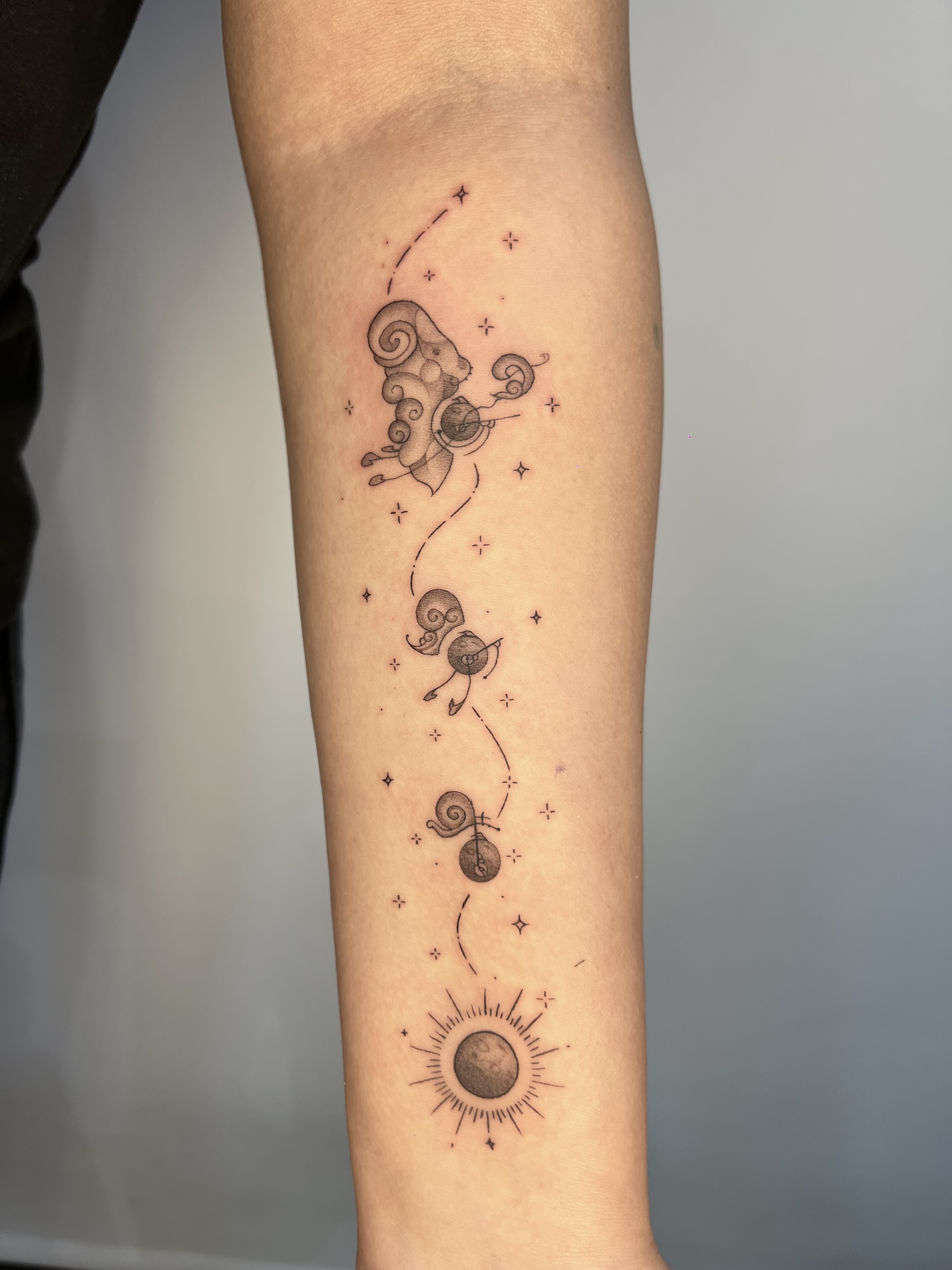 Tatuaje constelación Aries caracoles sol y estrellas fineline antebrazo — Sebastián, CAOS Art Tattoo Chile