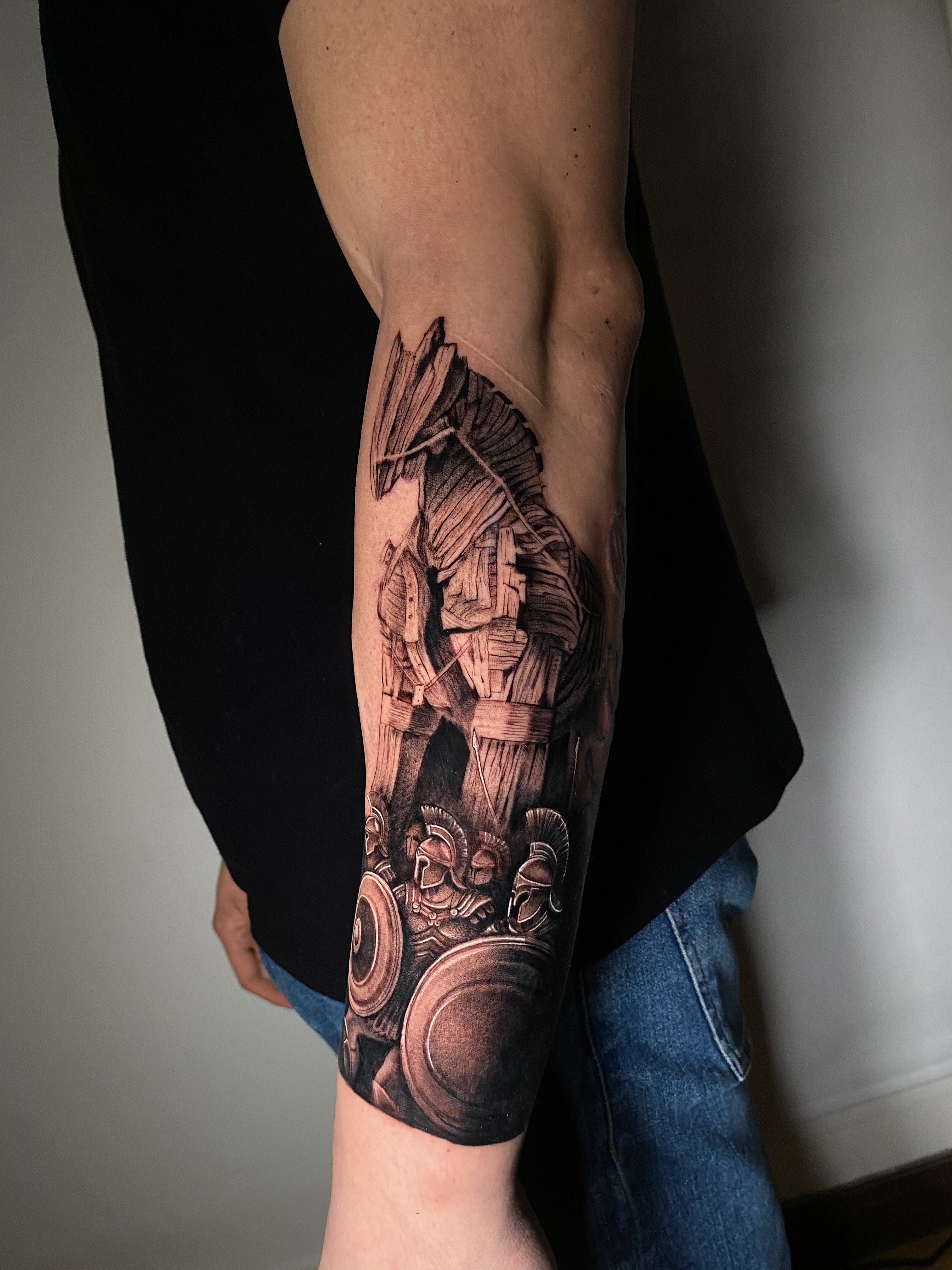 Tatuaje caballo de Troya con guerreros espartanos brazo black grey — Krimatt, CAOS Art Tattoo Chile