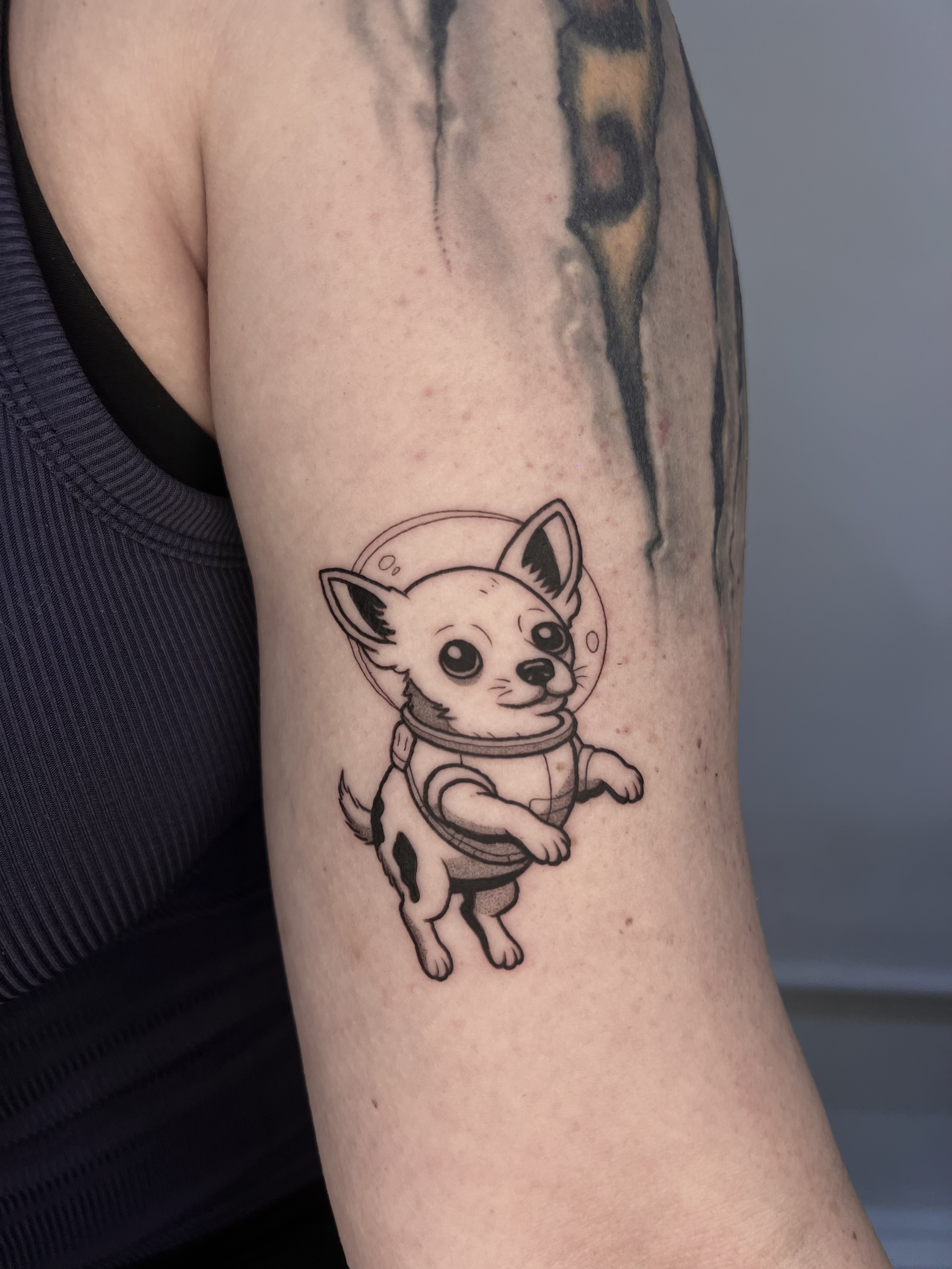Tatuaje Chihuahua astronauta blackwork brazo — CAOS Art Tattoo Chile