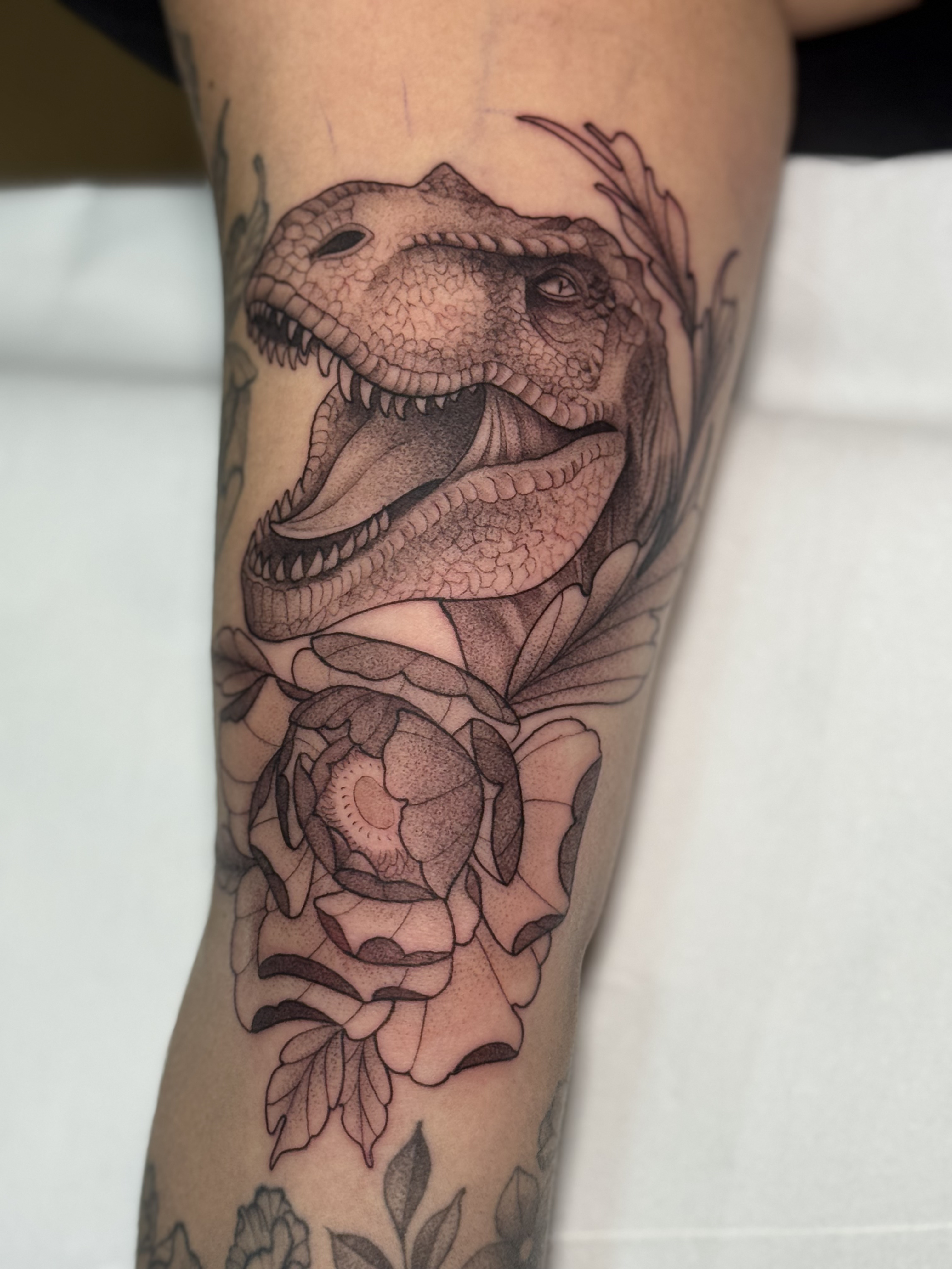 Tatuaje dinosaurio T-Rex con peonías black grey — CAOS Art Tattoo Chile