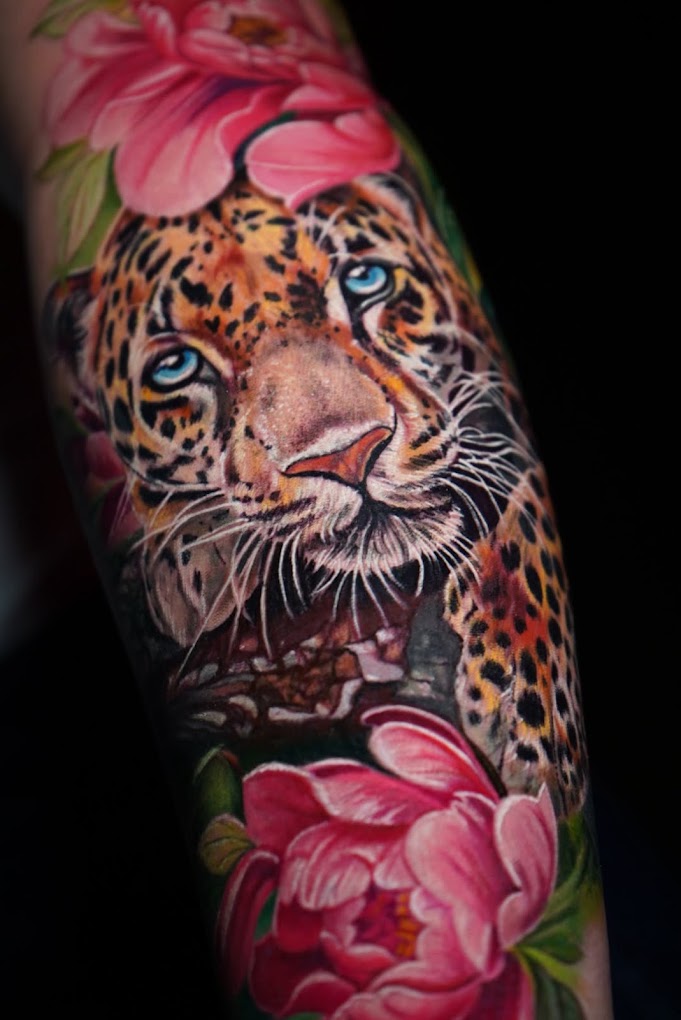 Tatuaje jaguar realismo color con peonías brazo completo — CAOS Art Tattoo Chile