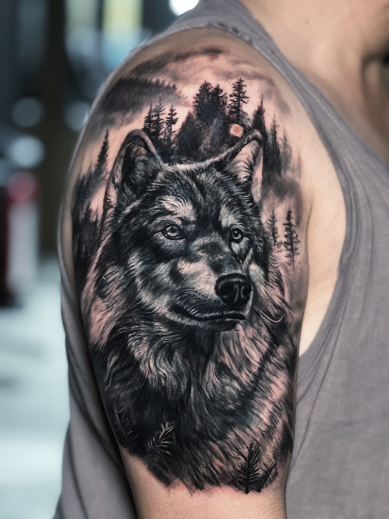 Tatuaje Lobo realista con bosque doble exposición hombro — CAOS Art Tattoo Chile