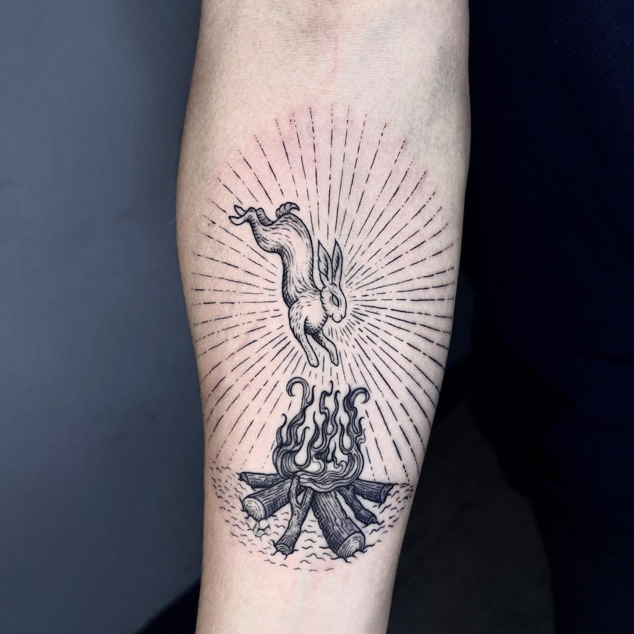 Tatuaje conejo saliendo del fuego ilustrativo blackwork — Nati, CAOS Art Tattoo Chile
