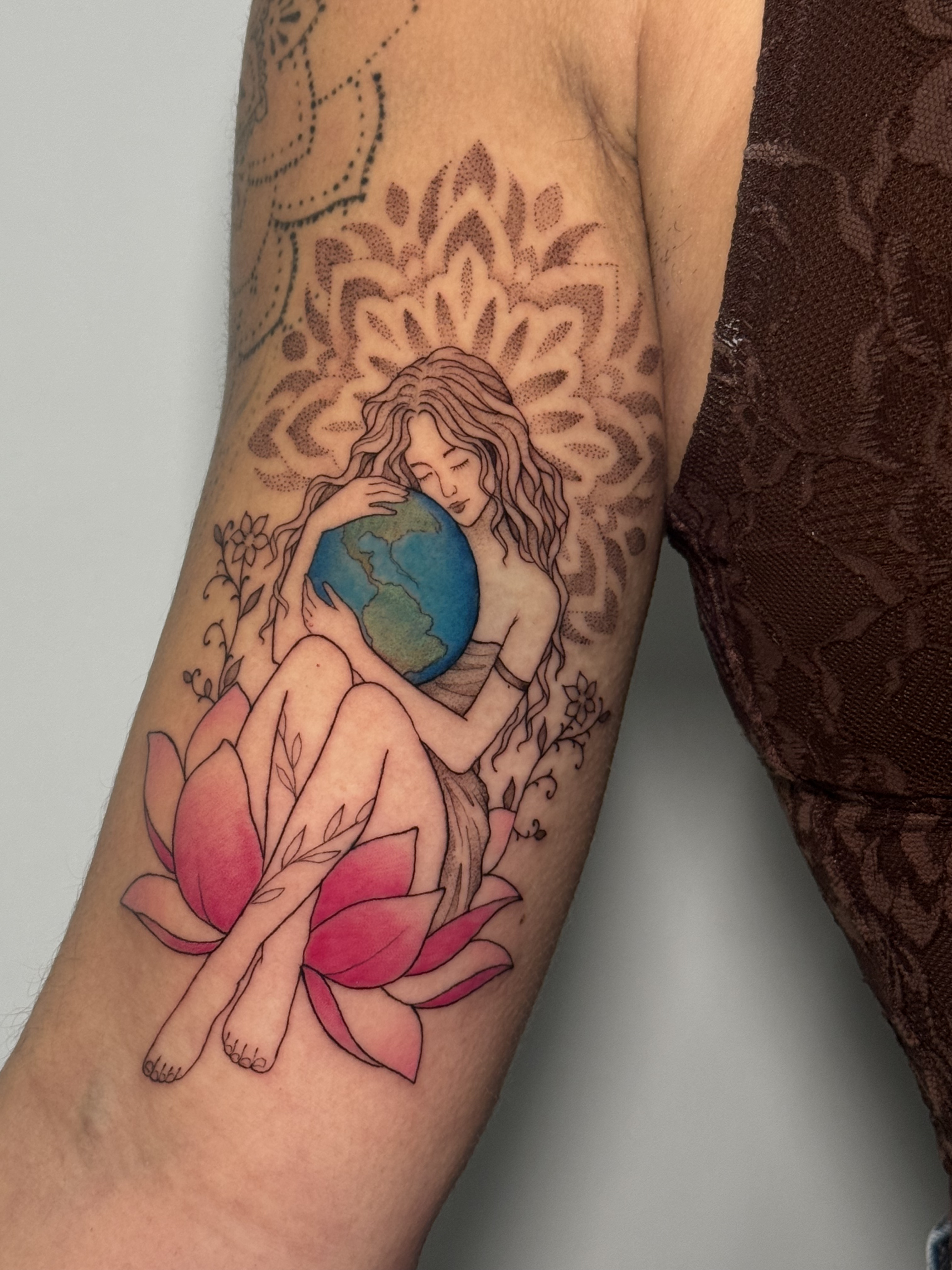 Tatuaje mujer sosteniendo el planeta Tierra con loto y mandala fineline acuarela — Krimatt, CAOS Art Tattoo Chile