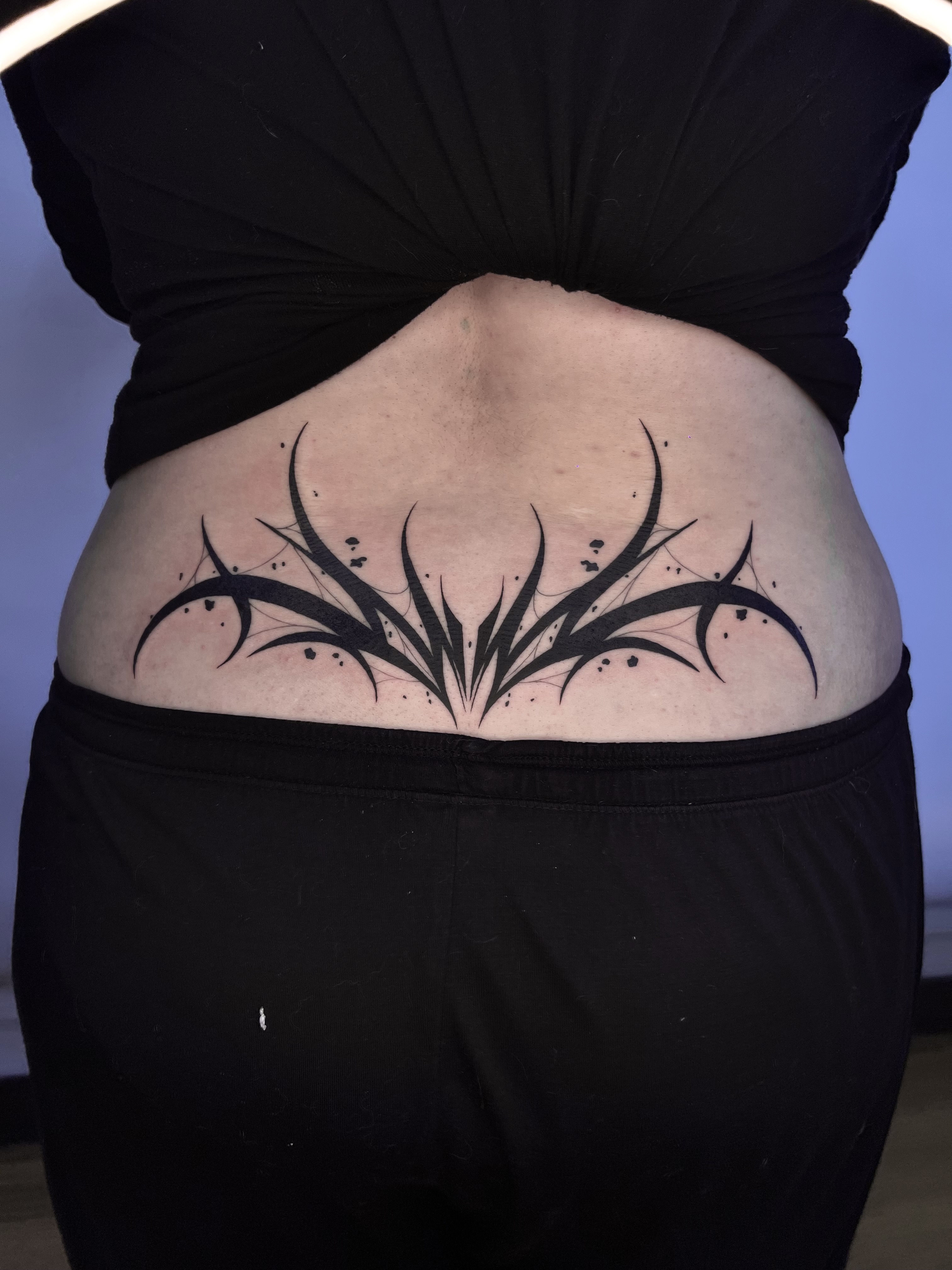 Tatuaje neo-tribal blackwork zona lumbar — Sebastián, CAOS Art Tattoo Chile