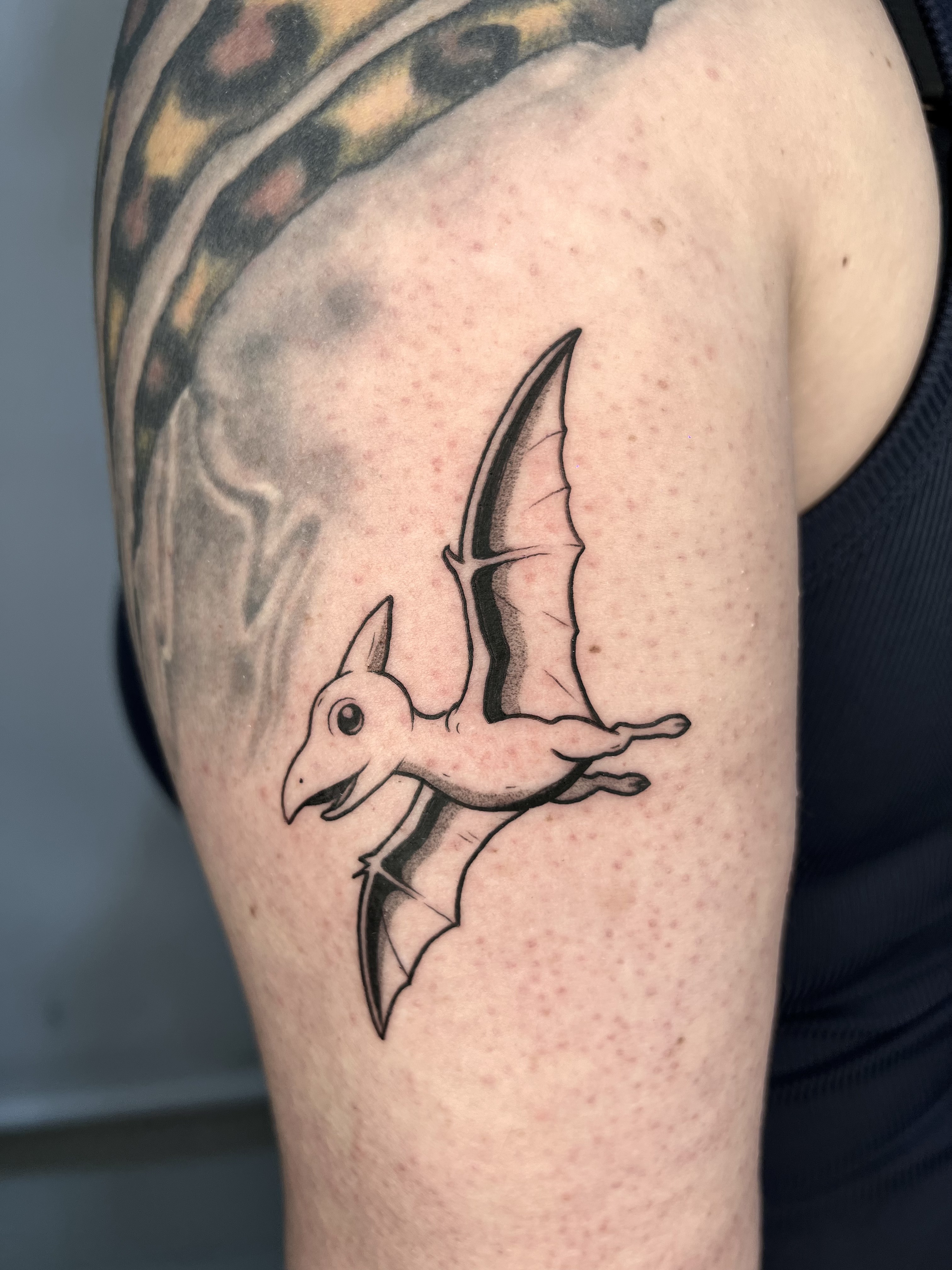 Tatuaje Pterodáctilo volando blackwork brazo — CAOS Art Tattoo Chile
