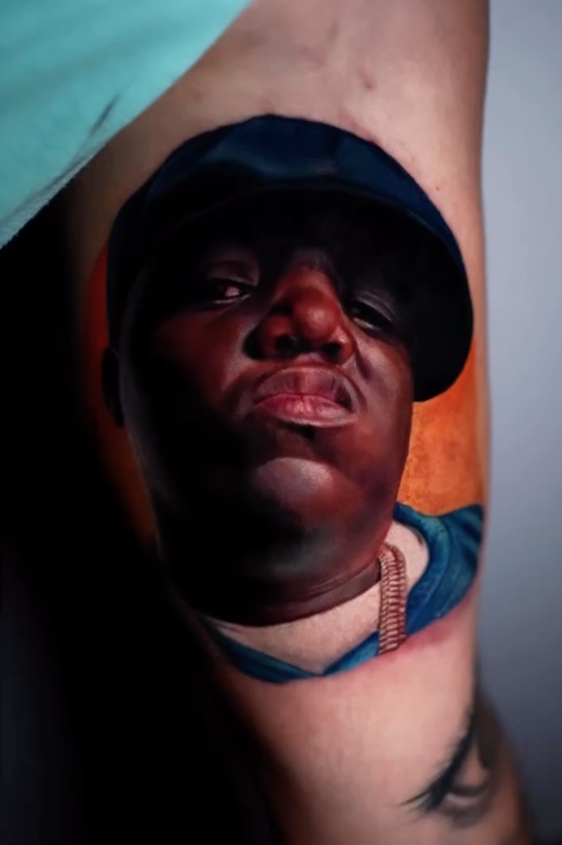 Tatuaje realismo retrato masculino gorra fondo naranja color — CAOS Art Tattoo Chile