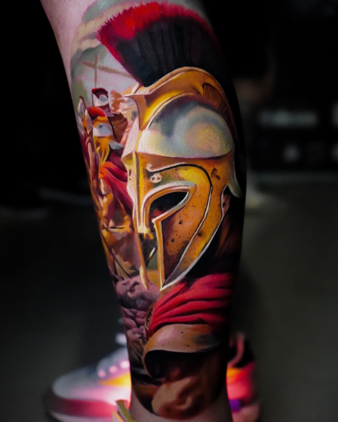 Tatuaje realismo color casco espartano guerrero pierna — CAOS Art Tattoo Chile