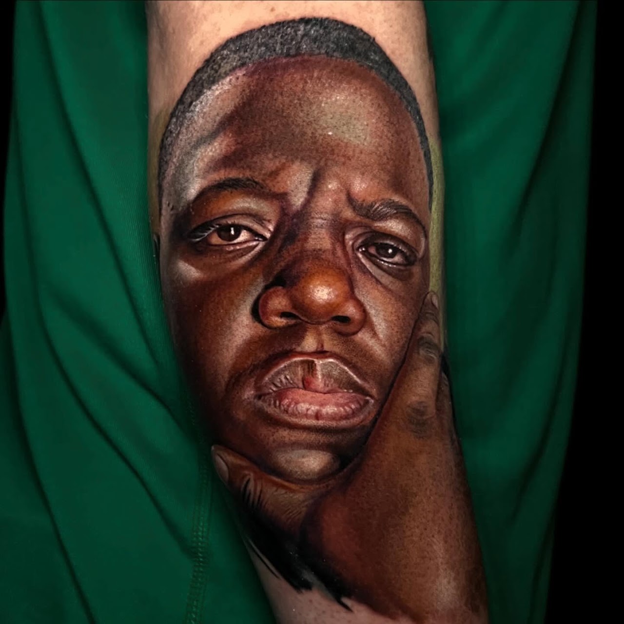 Tatuaje realismo retrato hombre mano en mejilla color detalle — CAOS Art Tattoo Chile