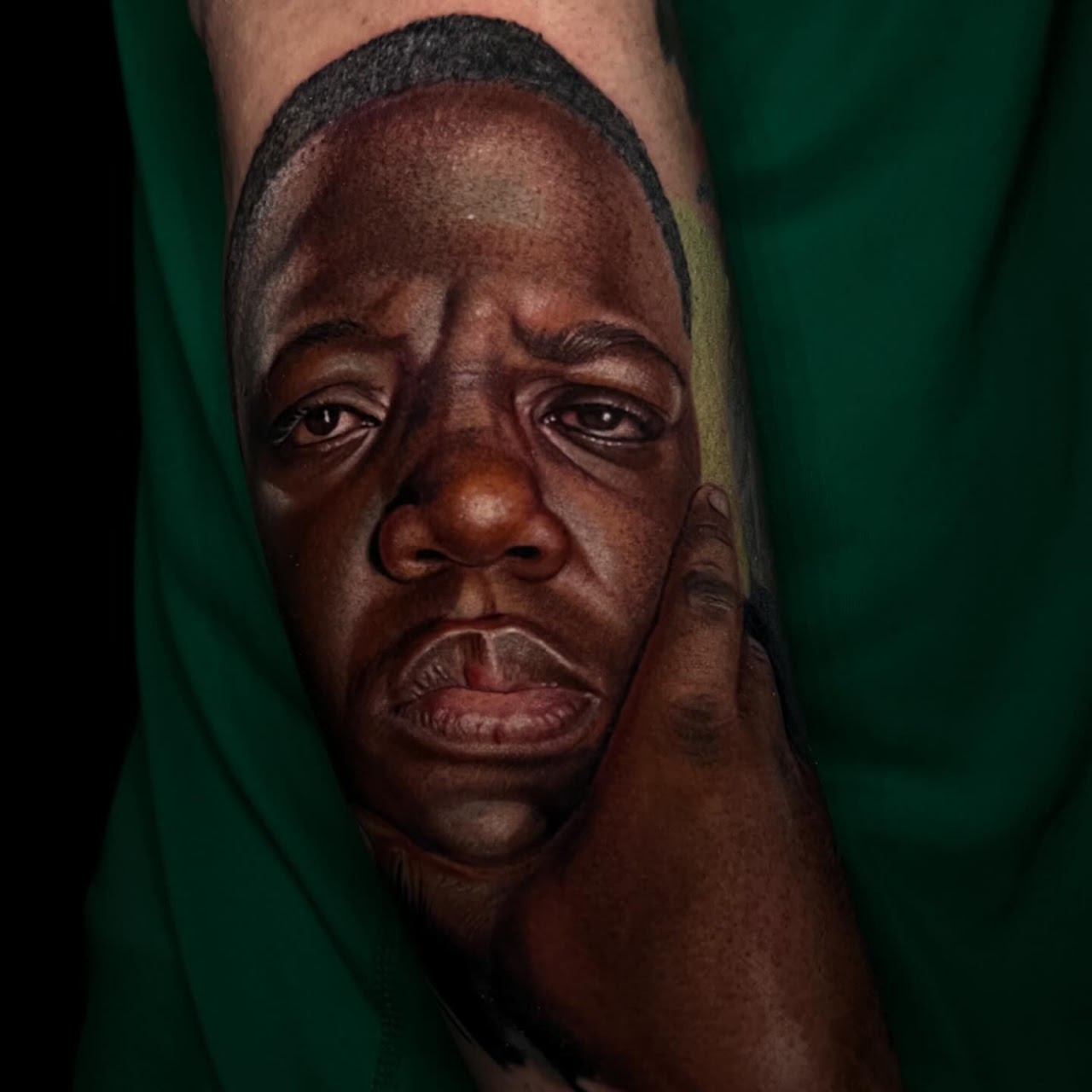 Tatuaje realismo retrato hombre mano en mejilla color acercamiento — CAOS Art Tattoo Chile
